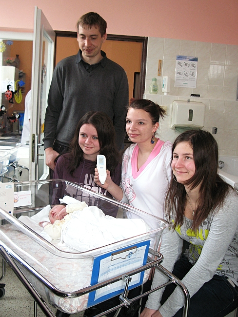 Studentky se starostou města u postýlky s novorozencem
